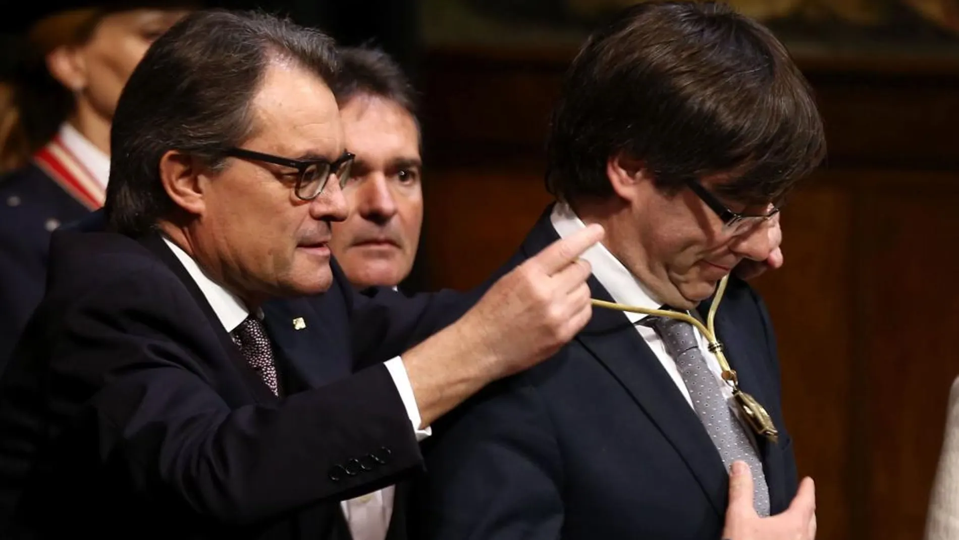 El expresidente de la Generalitat, Artur Mas, impone la medalla representativa del cargo al nuevo presidente de la Generalitat de Cataluña