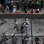 La Guardia Nacional Bolivariana se enfrenta a dos jóvenes opositores ayer, en el centro de Caracas