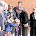 Un niña entrega a la Reina Sofía un ramo de flores a su llegada