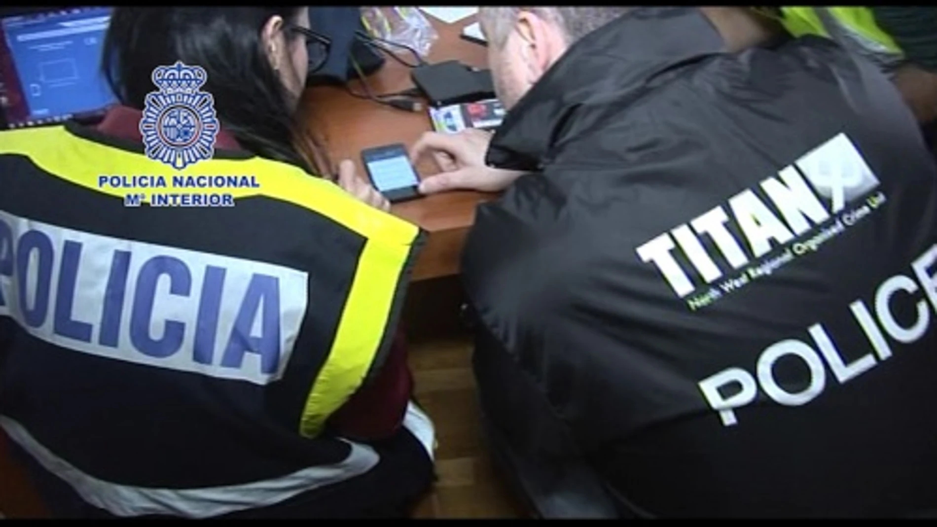 Dos agentes examinan el material incautado