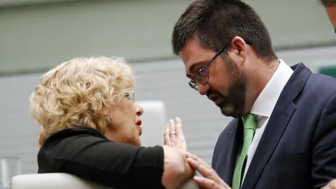 El ex concejal de Economía y Hacienda de Ahora Madrid, Carlos Sánchez Mato, conversa con la ex alcaldesa de Madrid, Manuela Carmena, durante un pleno en el Ayuntamiento de Madrid