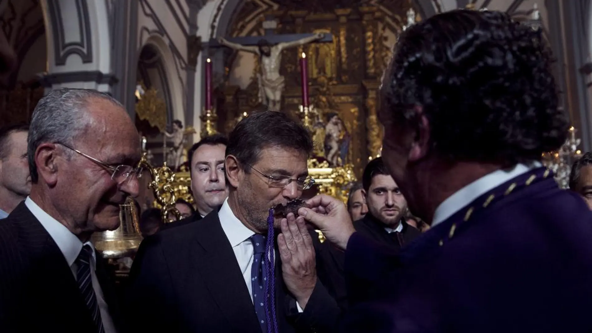MÁLAGA. El ministro de Justicia, Rafael Catalá, besa la medalla de la hermandad de las Fusionadas
