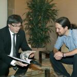 El presidente de la Generalitat, Carles Puigdemont, junto al líder de Podemos, Pablo Iglesias al que ha regalado un libro