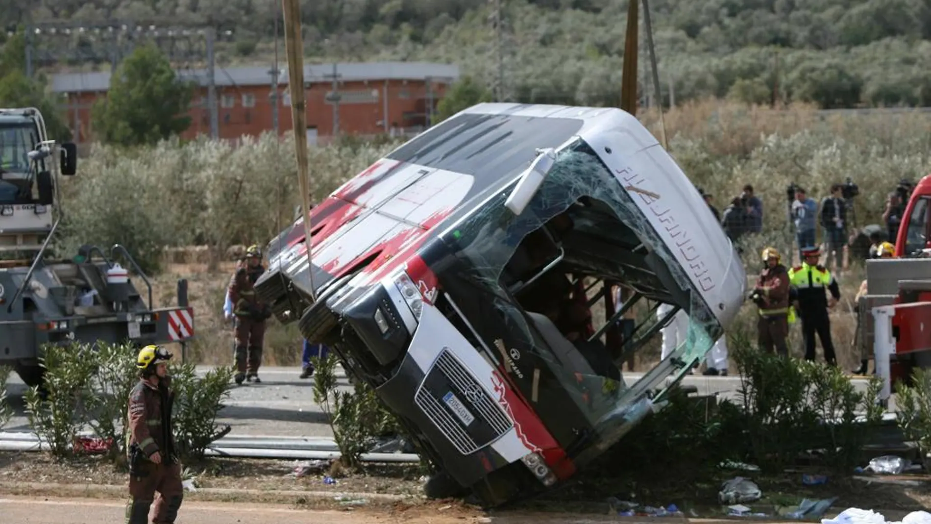 Efectivos del cuerpo de bomberos en el momento de levantar el autocar perteneciente a la empresa de Mollet del Vallès (Barcelona), que colisionó en la AP-7.