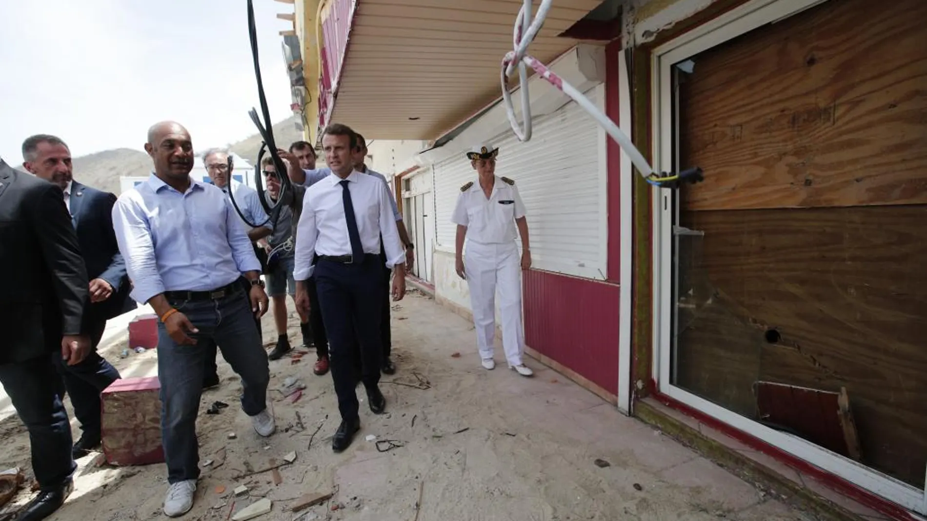 El presidente de Francia, Emmanuel Macron (c), observa los daños a una residencia durante una visita a la isla caribeña de San Martín (Francia) para evidenciar los daños causados tras el paso del huracán Irma ayer