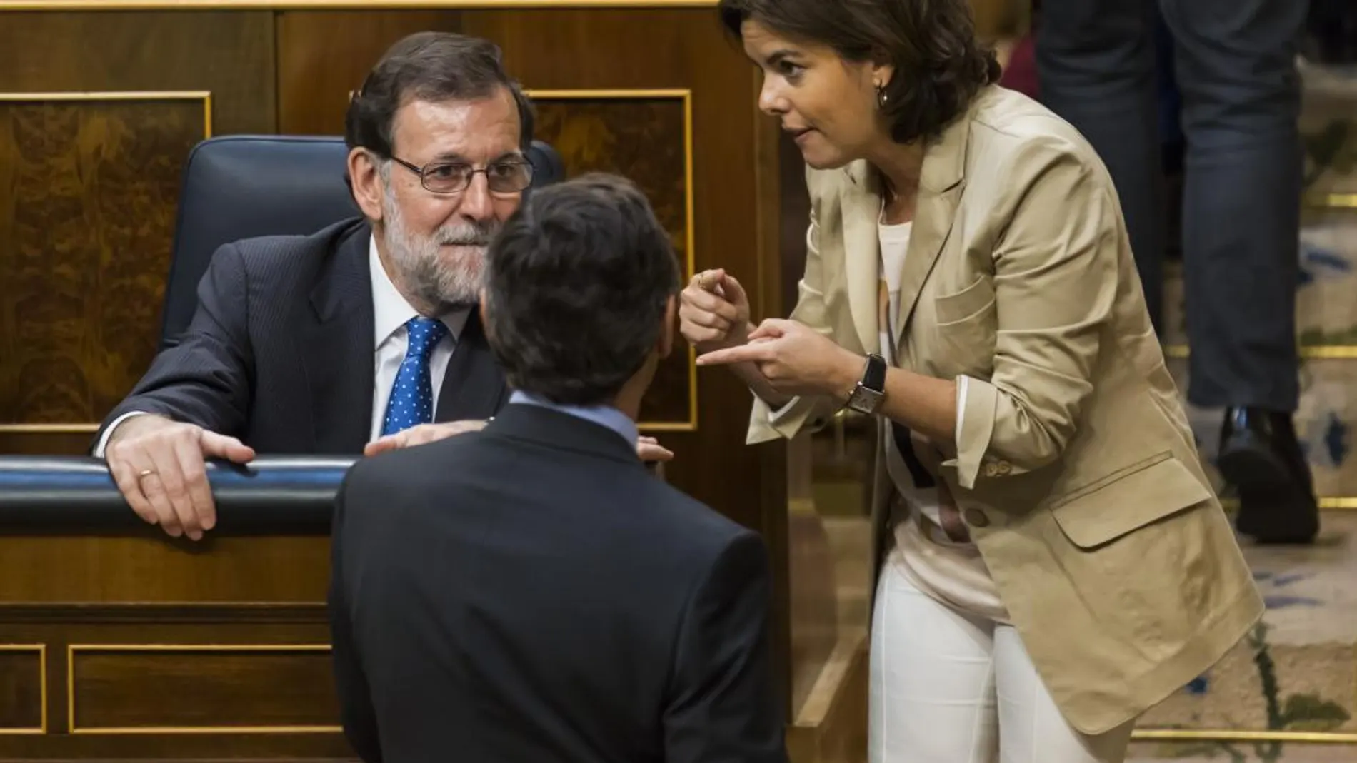 Mariano Rajoy charla en su escaño con Soraya Sáenz de Santamaría