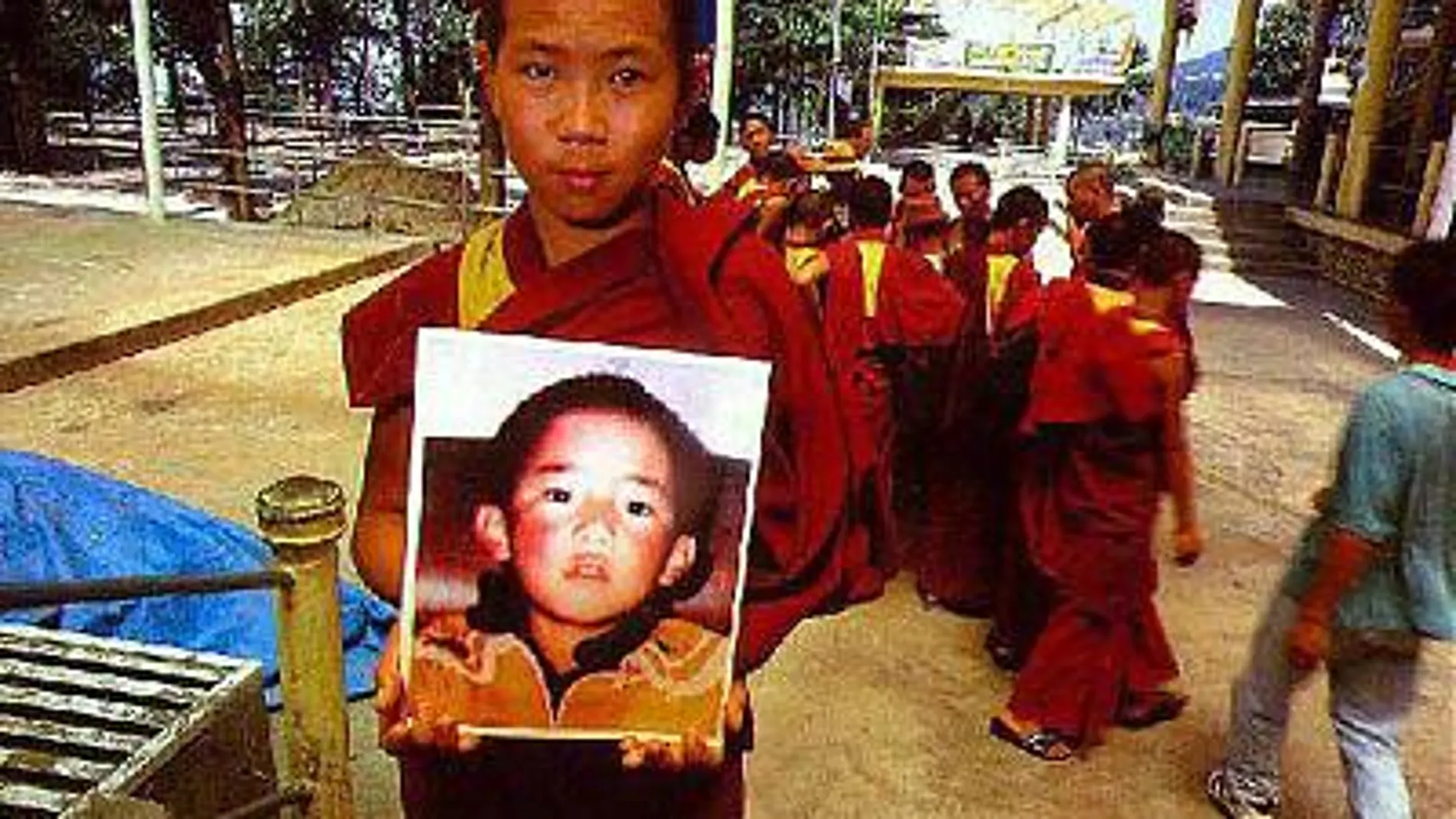 Un joven sostiene un afotografía de Gendun Choekyi Nyima, ahora de 26 años, que fue puesto en custodia por las autoridades chinas a la edad de 6 años.