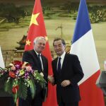 El ministro de Asuntos Exteriores chino, Wang Yi (d), estrecha la mano de su homólogo francés, Jean-Marc Ayrault, durante una rueda de prensa conjunta.