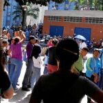 Venezolanos hacen fila para intentar comprar comida a las afueras de un supermercado en Caracas, ayer