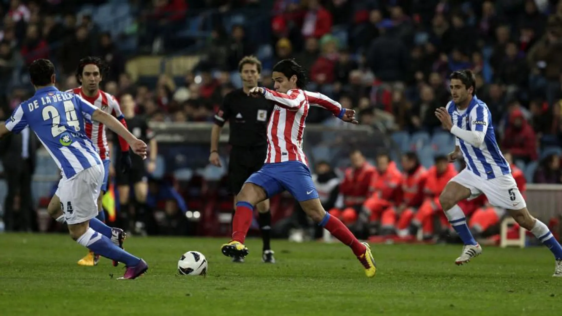 El delantero colombiano del Atlético de Madrid Radamel Falcao avanza con el balón ante el defensa de la Real Sociedad Alberto De la Bella