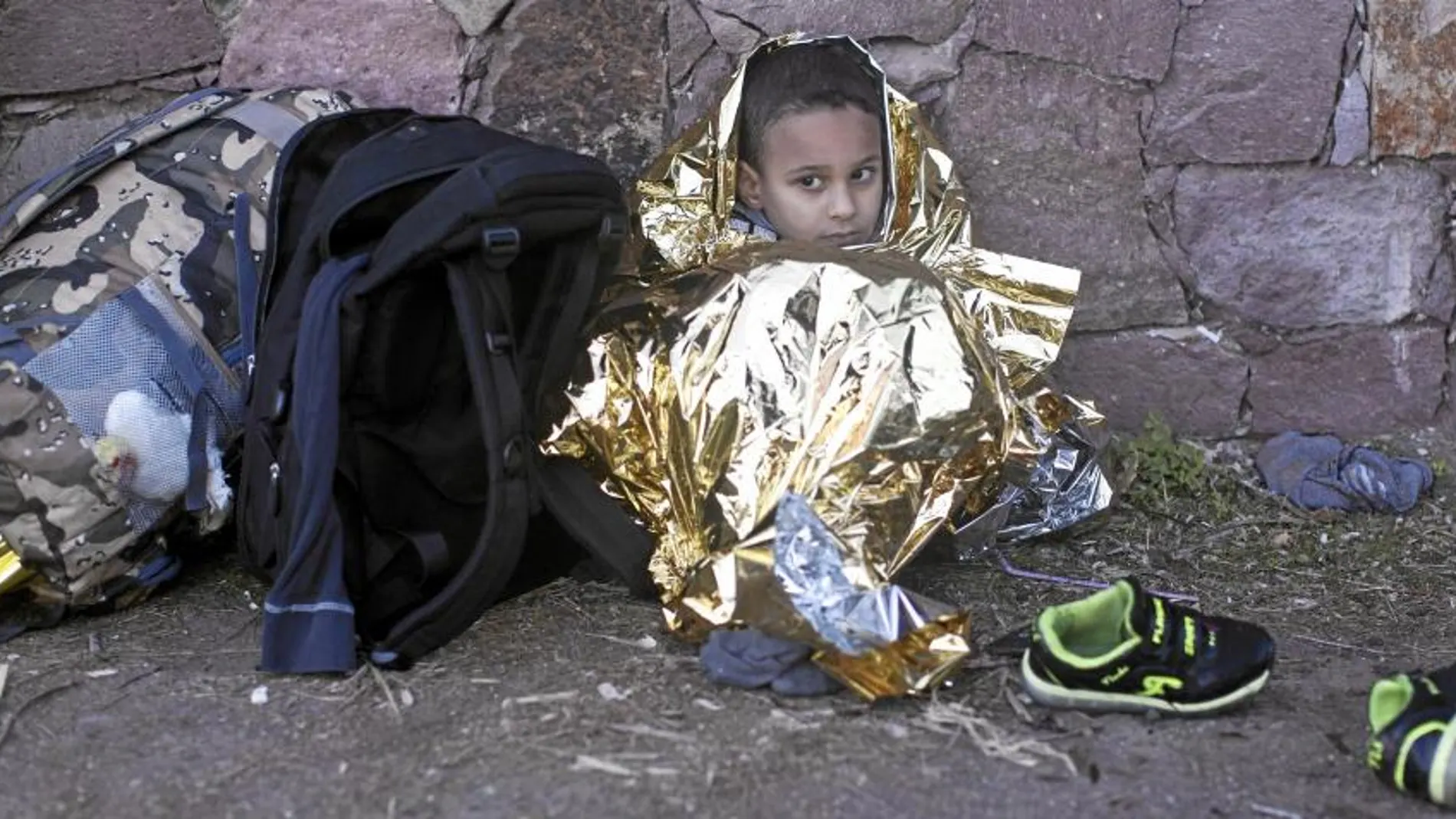 Un niño se abriga con una manta térmica tras desembarcar ayer con un pequeño bote en la isla griega de Lesbos