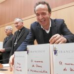 En primer plano, el cómico Roberto Benigni coloca varias ediciones del libro del Papa. Detrás, Pietro Parolin y Federico Lombardi