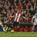 El delantero del Athletic de Bilbao Iker Muniain (c) entre el centrocampista Asier Illarramendi (i) y el defensa Aritz Elustondo (d), de la Real Sociedad
