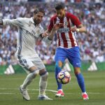 El defensa del Real Madrid Sergio Ramos (i) disputa un balón con el jugador belga del Atlético de Madrid Yannick Carrasco