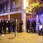 Varios antidisturbios junto al "banco okupado", esta noche en Barcelona, donde se ha vivido una nueva noche de disturbios en el barrio de Gràcia y donde se han reproducido los enfrentamientos entre jóvenes y fuerzas antidisturbios de los Mossos d'Esquadra.