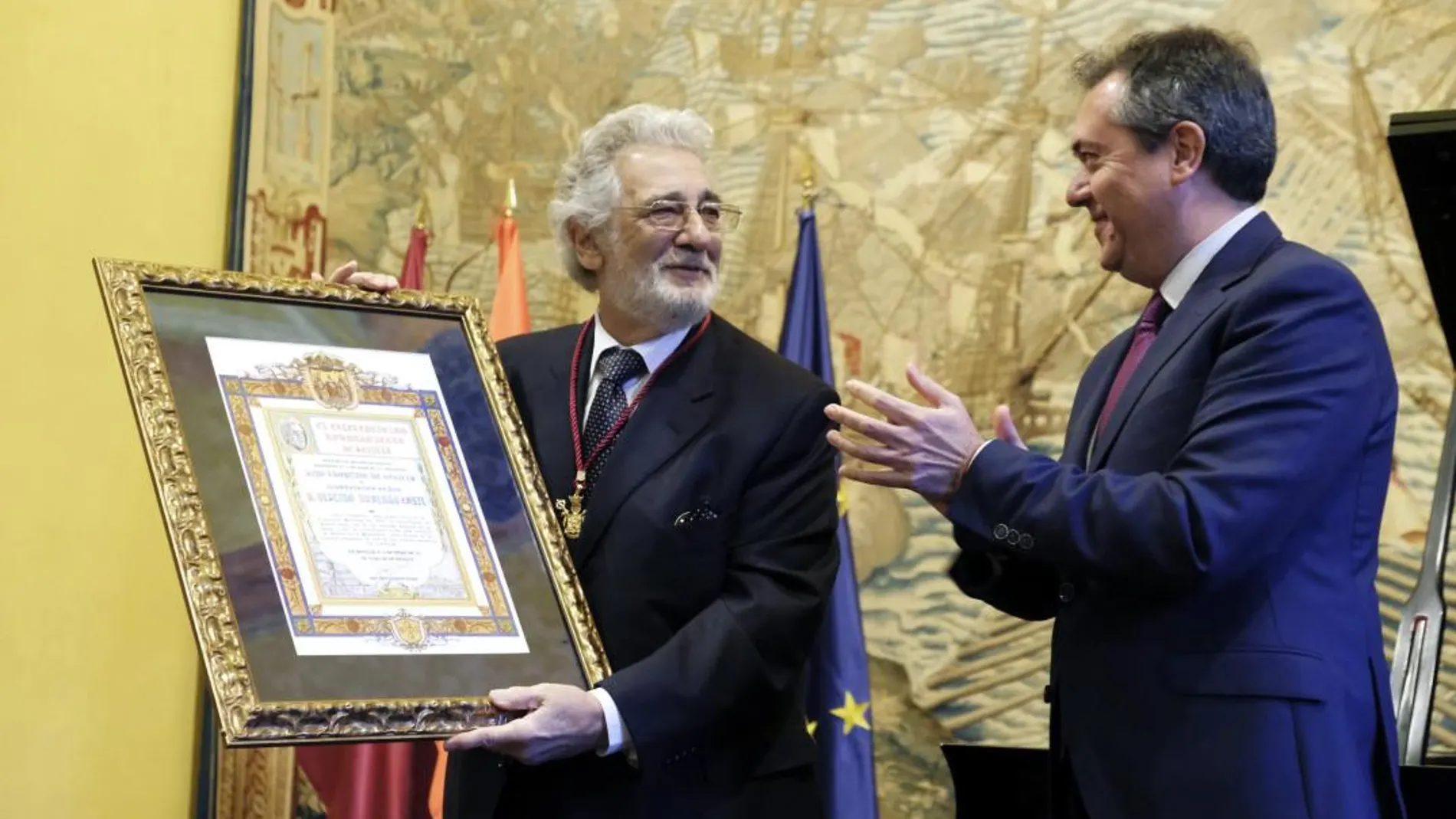 El tenor Plácido Domingo (i), es aplaudido por el alcalde sevillano, Juan Espadas, tras hacerle entrega de la medalla de la ciudad al ser nombrado hijo adoptivo de Sevilla