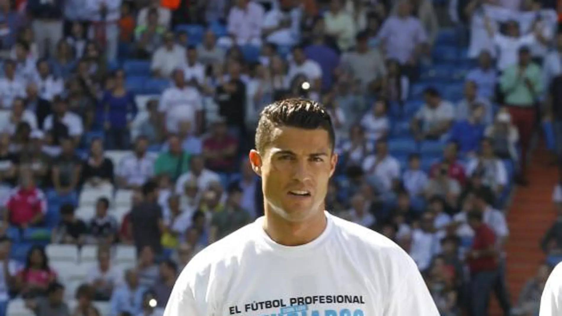 Zaid Abdul en el césped del Santiago Bernabéu vestido con la equipación del Real Madrid junto a Cristiano Ronaldo.