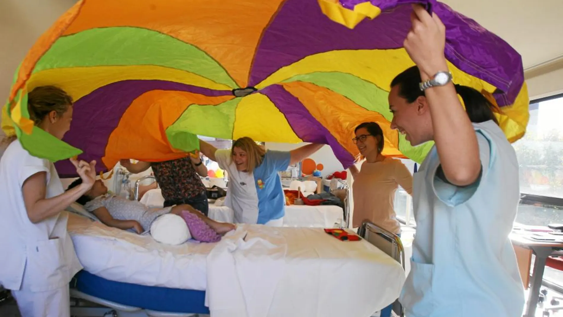 Varias enfermeras estimulan a la pequeña Laila con pañuelos de colores. También recibe musicoterapia en el centro Laguna de Madrid