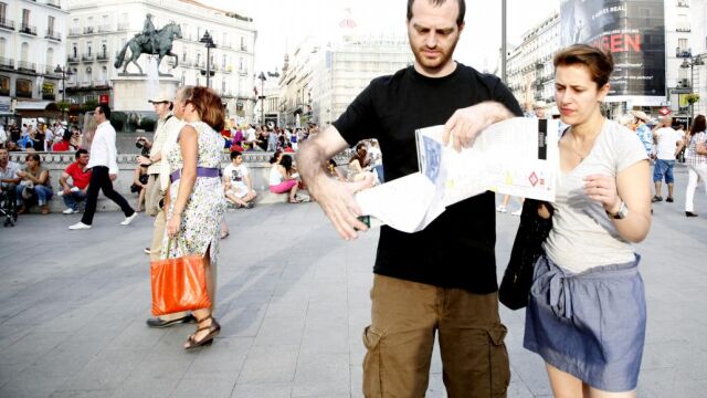 Dos turistas consultan un mapa en la Puerta del Sol de Madrid