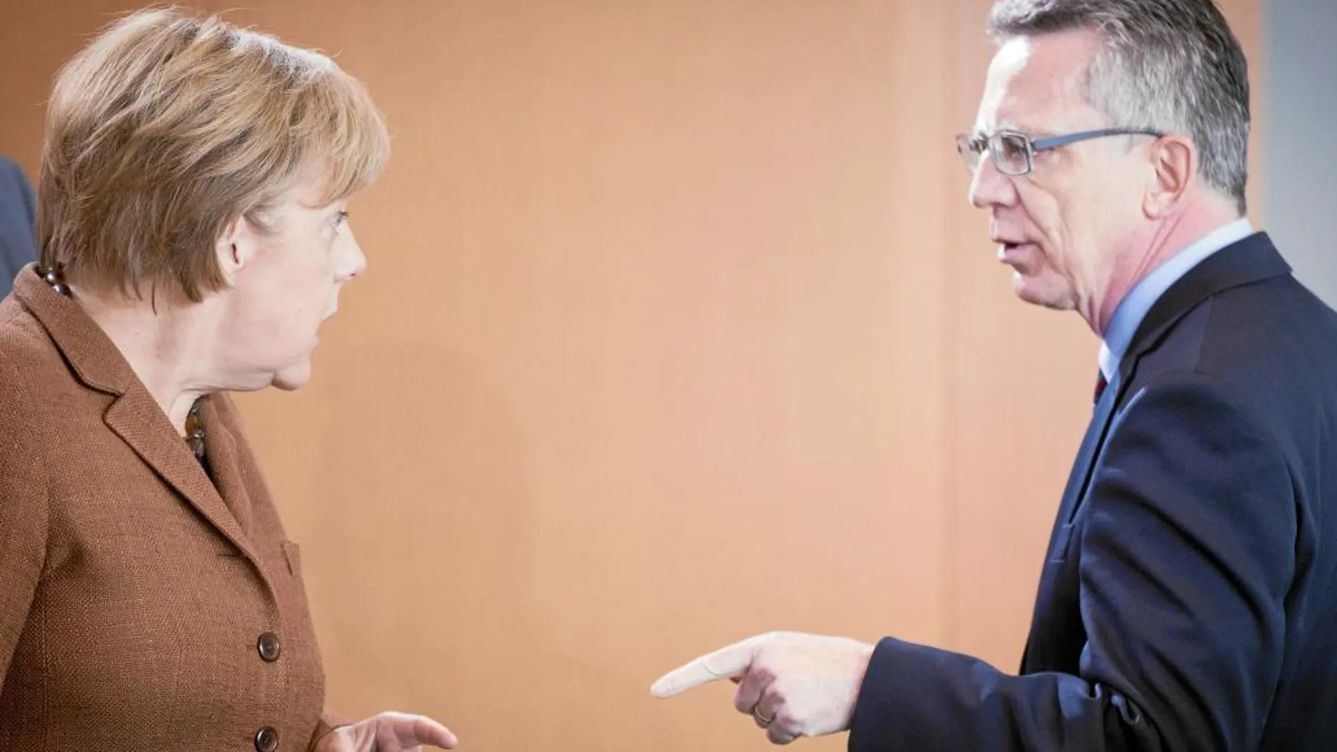 La canciller alemana, Angela Merkel, junto al ministro del Interior, Thomas de Maiziere