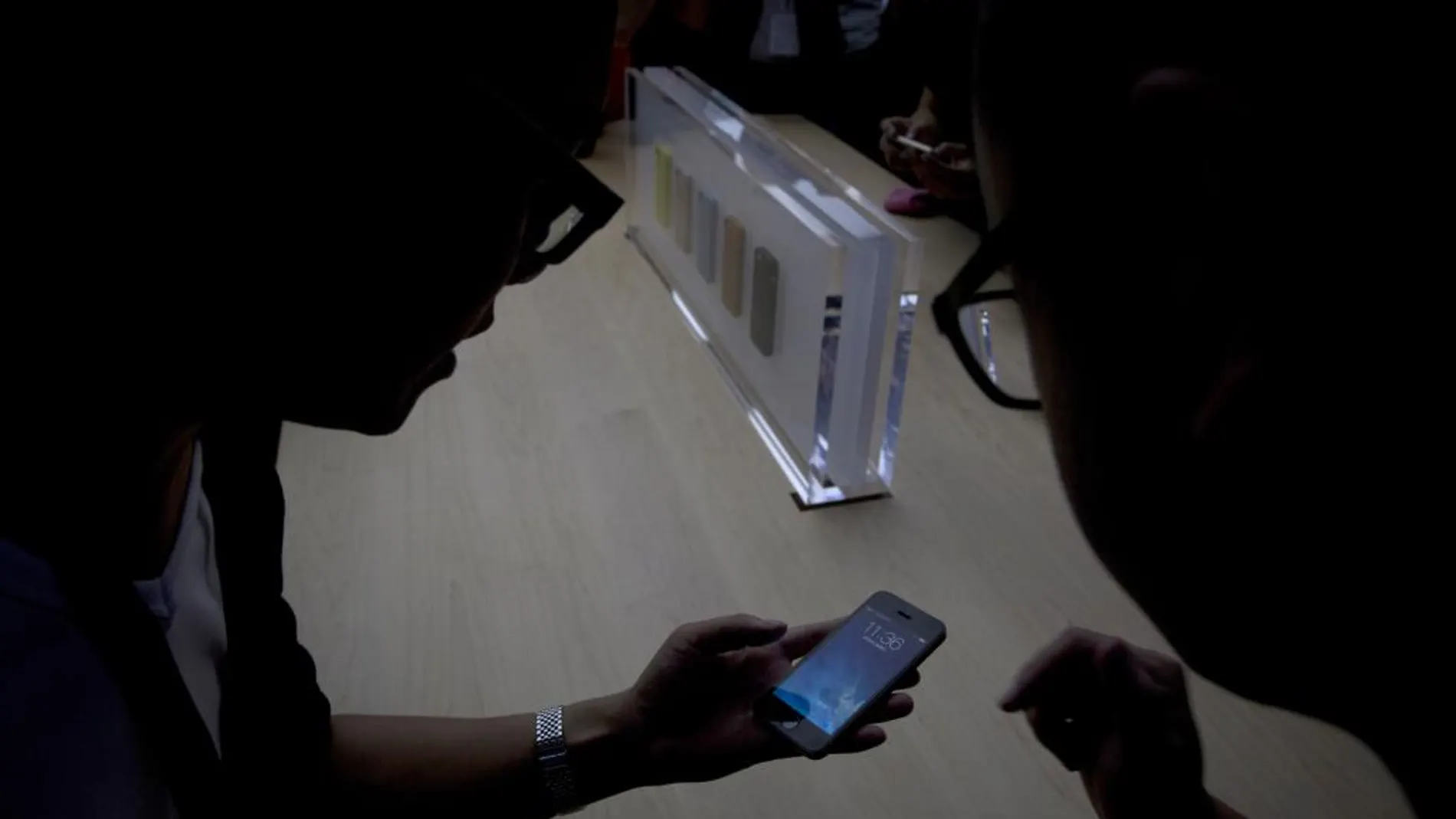 Dos usuarios consultan un móvil, en una imagen de archivo