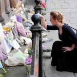 Una mujer deja un ramo de flores en el centro de Manchester para honrar a las víctimas del ataque en el Manchester Arena