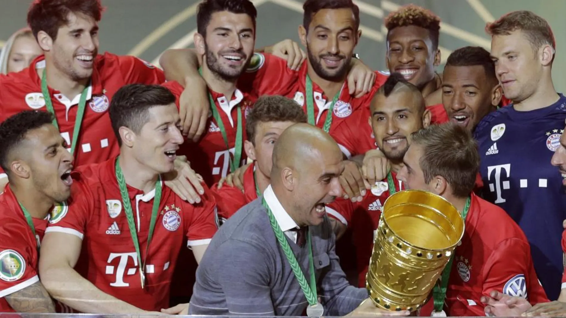 Pep Guardiola rodeado de sus jugadores con el trofeo de la Copa de Alemania