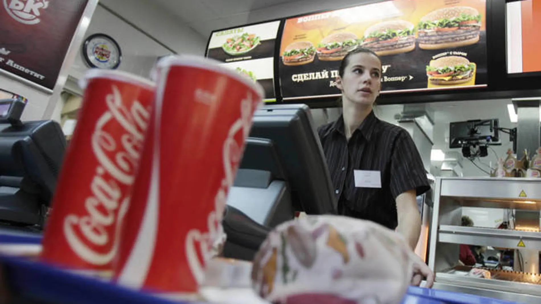 Una empleada de Burger King sirve menús