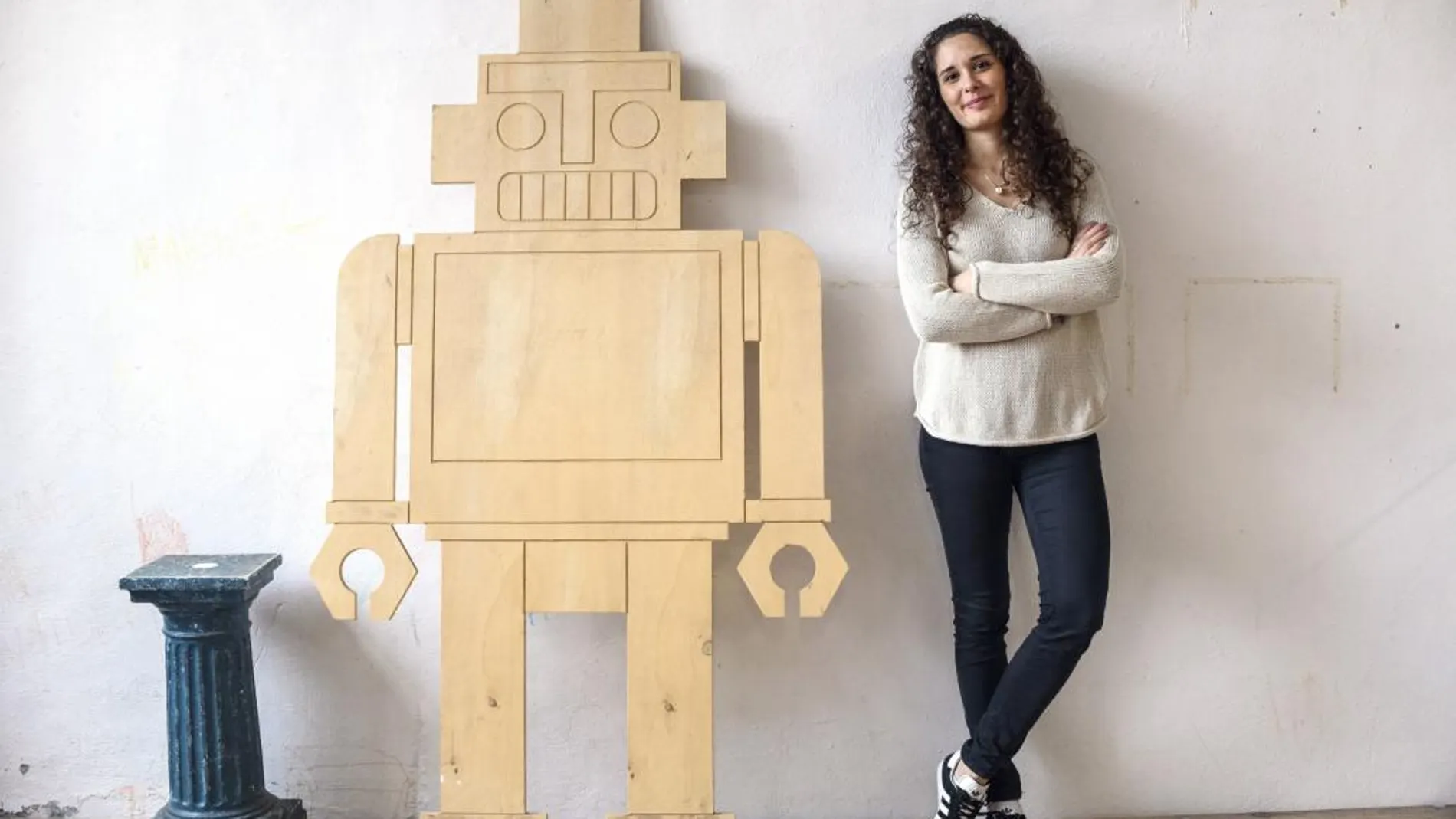 La ingeniera electrónica Nerea de la Riva, de 25 años y natural de Alcalá de Henares (Madrid), tetracampeona del mundo de robots futbolistas, posa junto a la figura de un robot