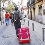 Un turista recorre las calles del barrio de Malasaña, uno de los más afectados por la «turistificación», con una maleta