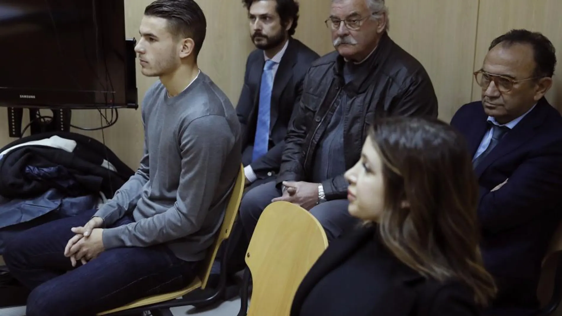 El futbolista del Atlético de Madrid Lucas Hernández (i), durante el juicio por el incidente que protagonizó junto a su novia Amelia De la Ossa (d) el pasado 2 de febrero en su piso de Madrid