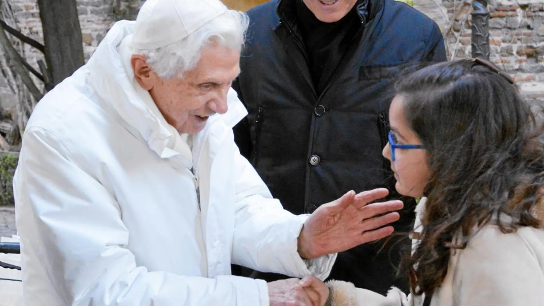 El Papa emérito Benedicto XVI, que ayer cumplió 89 años, saluda cariñosamente a la pequeña Ana