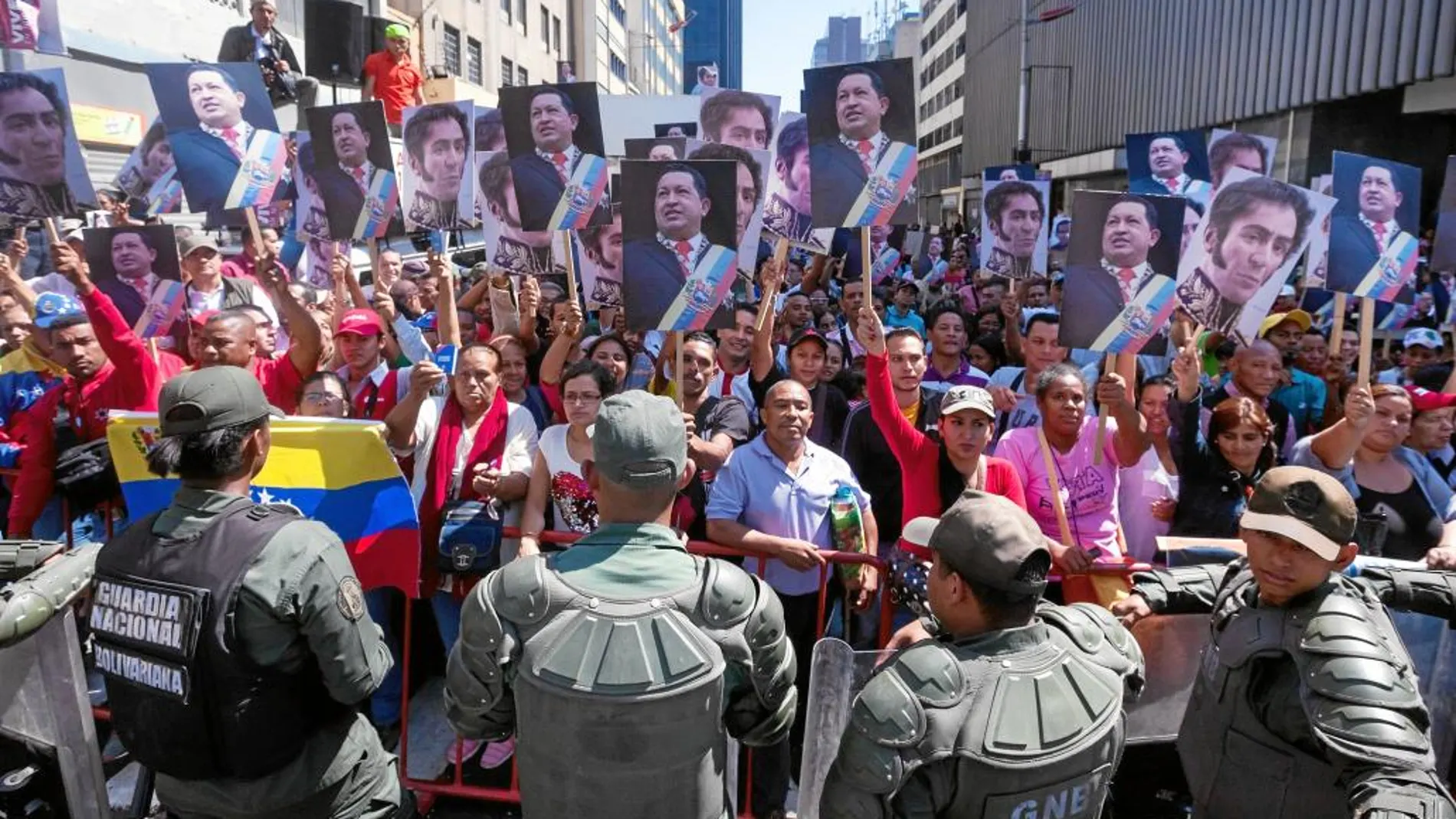 Seguidores de Chávez muestran carteles con fotos del difunto presidente y de Simón Bolívar, ayer, en Caracas