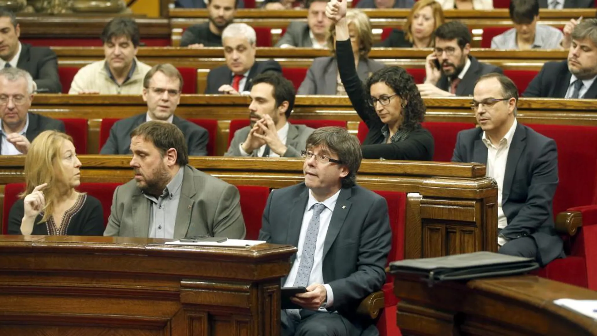 El presidente de la Generalitat, Carles Puigdemont (c), durante la votación en el pleno del Parlamento catalán sobre a moción de la CUP pactada con Junts pel Sí