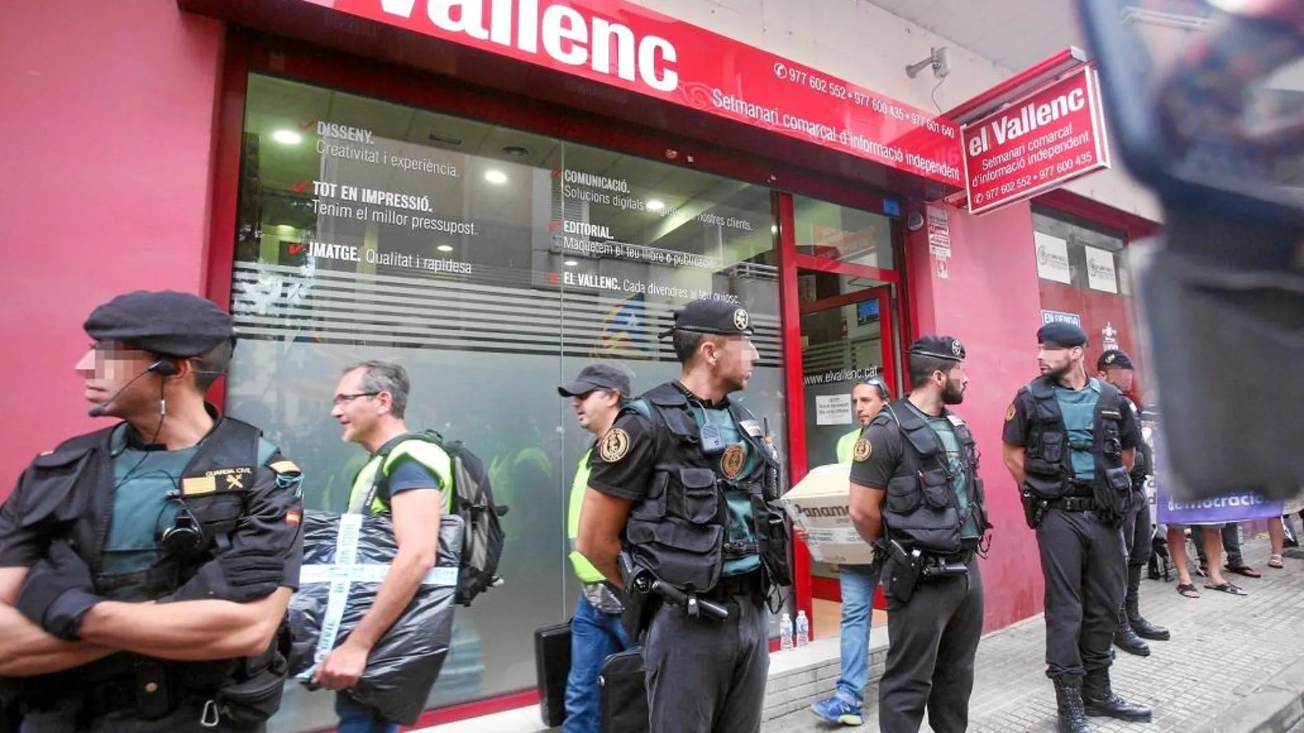Efectivos de la guardia civil transportan cajas a su salida del semanario El Vallenc