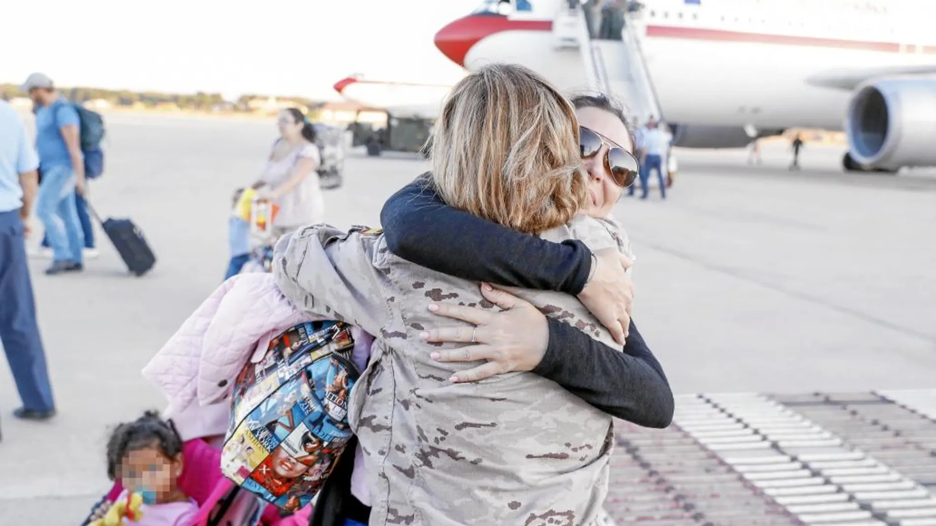 Una de las españolas repatriadas se abraza con un familiar a su llegada a Torrejón de Ardoz