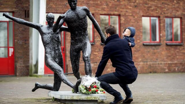 Un hombre deposita flores en la estatua de Johan Cruyff en el estadio Olímpico de Amsterdam Holanda tras conocerse la noticia de su muerte.