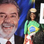 Una mujer sostiene un cartel con una imagen del expresidente de Brasil Luiz Inácio Lula da Silva durante una manifestación de Integrantes de las centrales obreras y los movimientos sociales simpatizantes del Gobierno