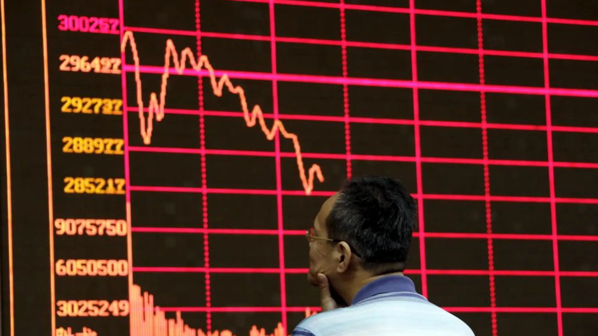 Un inversor analiza uno de los panales informativos de la Bolsa de Shanghai