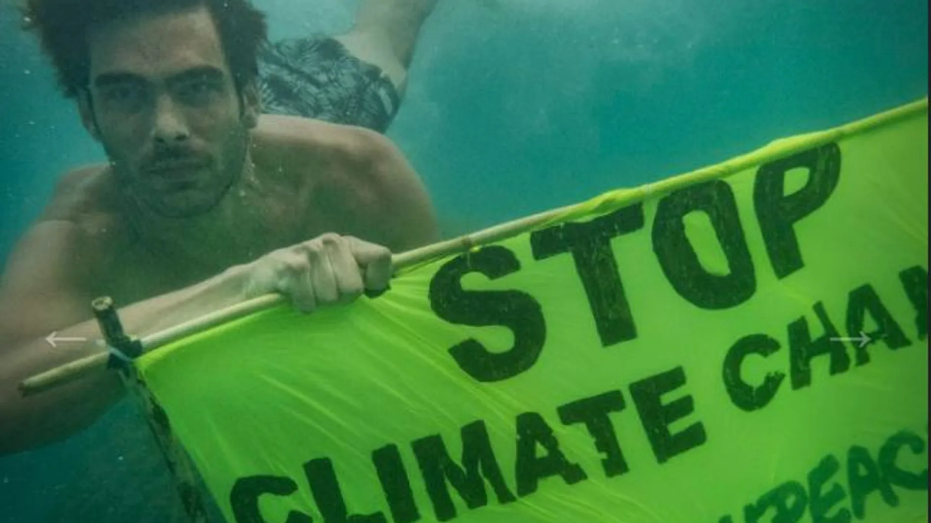 El actor buceando con una pancarta de Greenpeace