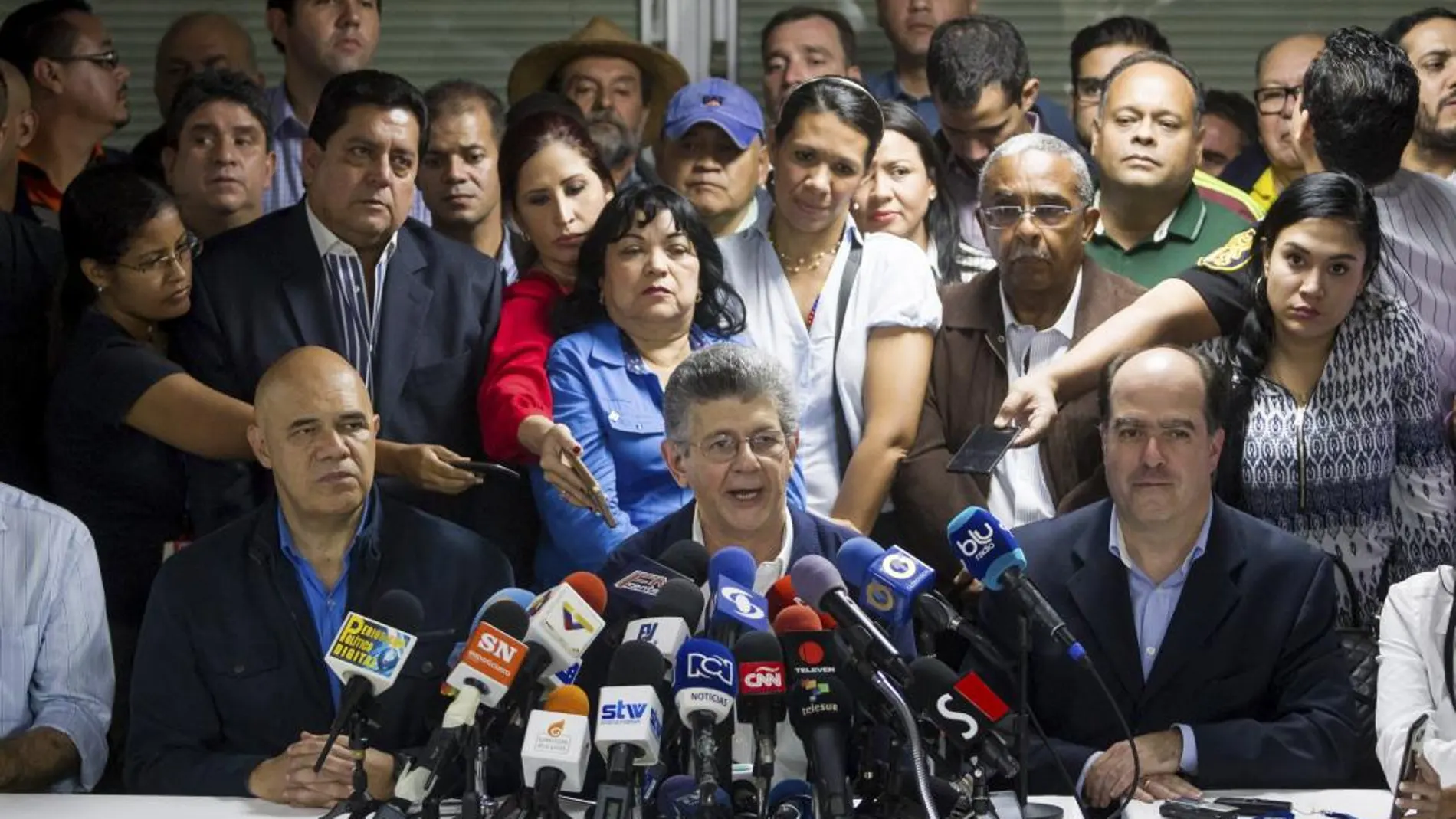 El diputado venezolano Henry Ramos Allup (c), acompañado por el secretario general de la Mesa de Unidad Democrática (MUD), Jesús Torrealba (i), y por el diputado Julio Borges (d), habla con la prensa tras ser elegido