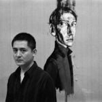 Zeng Fanzhi posa con uno de sus cuadros