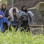Refugiados caminan por las vías del tren en la frontera entre Austria y Eslovenia en Spielfeld (Austria).