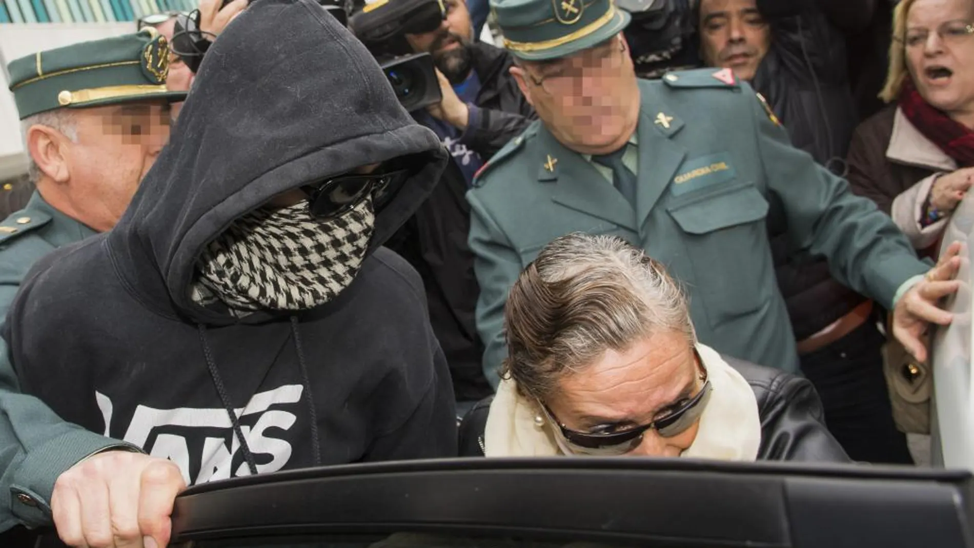 El Cuco, con la cabeza y la cara tapadas, acompañado por su madre, intentan entrar en un coche tras el juicio por incumplir la orden de alejamiento de la familia de Marta.