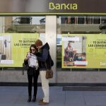 Tourists look at a city map in front of a Bankia bank branch in the Andalusian capital of Seville, southern Spain February 17, 2016. REUTERS/Marcelo del Pozo