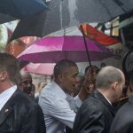 Obama se protege de la lluvia con un paraguas durante su visita a una zona comercial de Hanoi