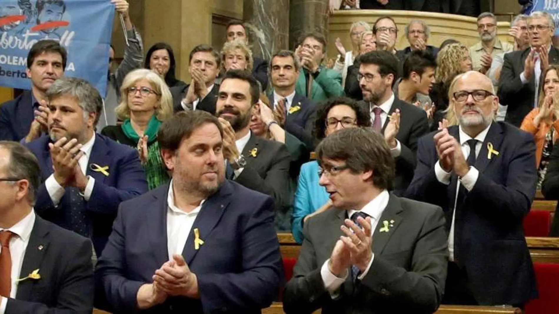 Carles Puigdemont y Oriol Junqueras junto a los diputados de JxSí y la CUP y sin los diputados del PSC, PPC y Ciudadanos, aplauden tras aprobarse en el pleno del Parlament, la declaración de independencia. EFE/ Alberto Estévez