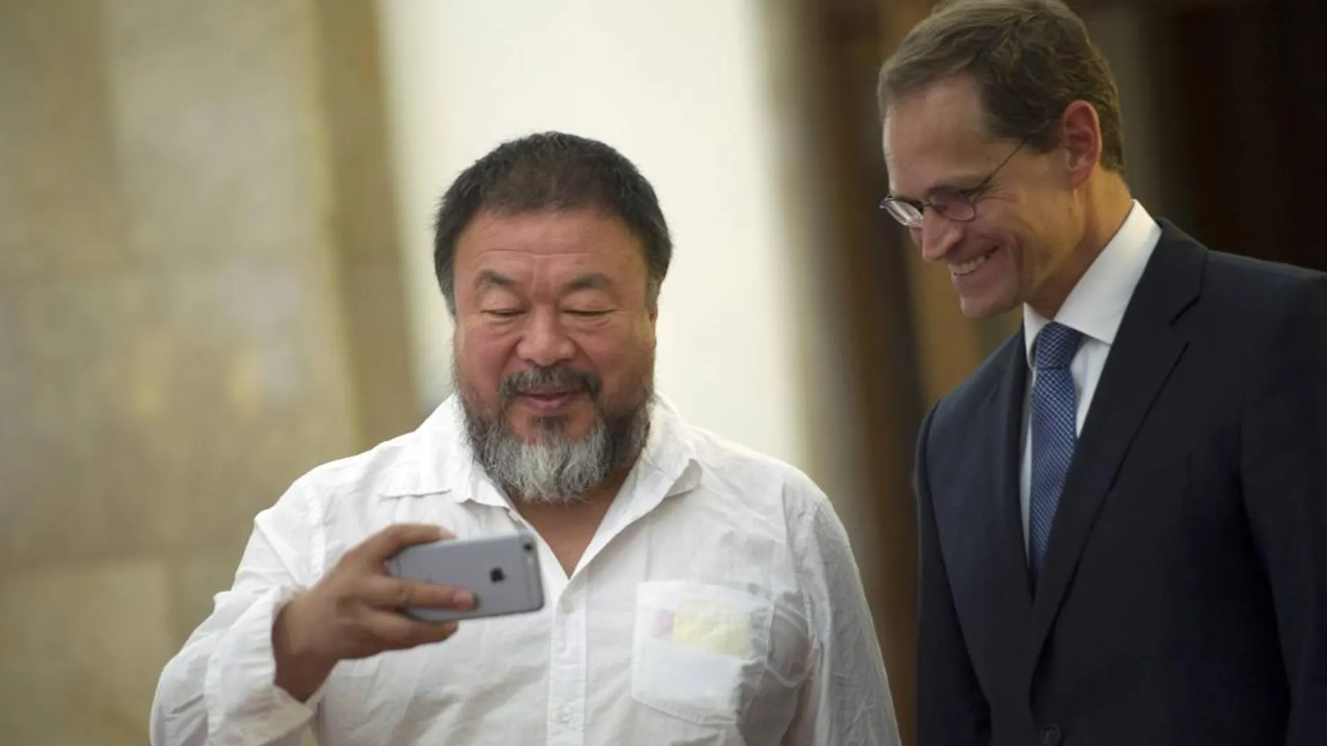 Ai Weiwei usando su smartphone junto al alcalde de Berlín, Michael Mueller, durante una visita a la ciudad el pasado mes de agosto