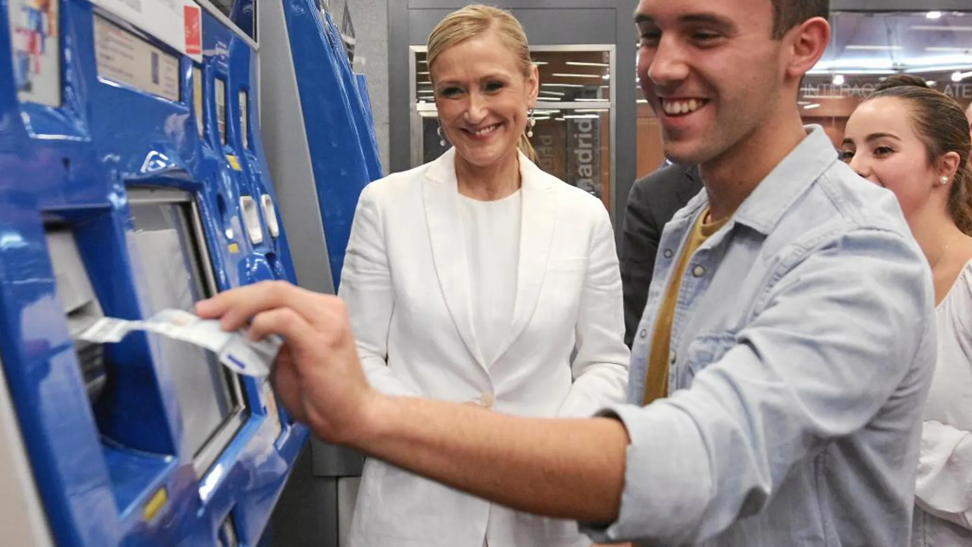 Cifuentes junto a un joven en el momento en el que recarga su abono