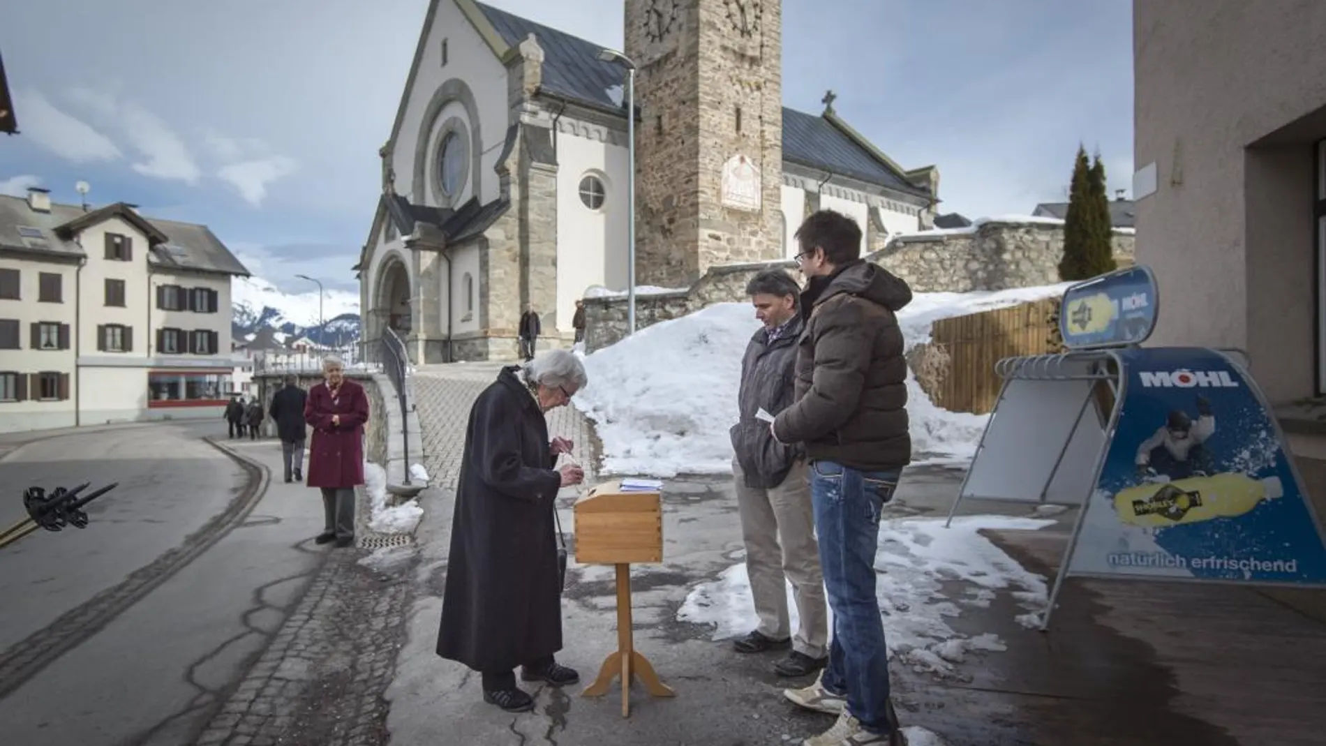 Una mujer deposita su papaleta en una urna en la calle en Obersaxen